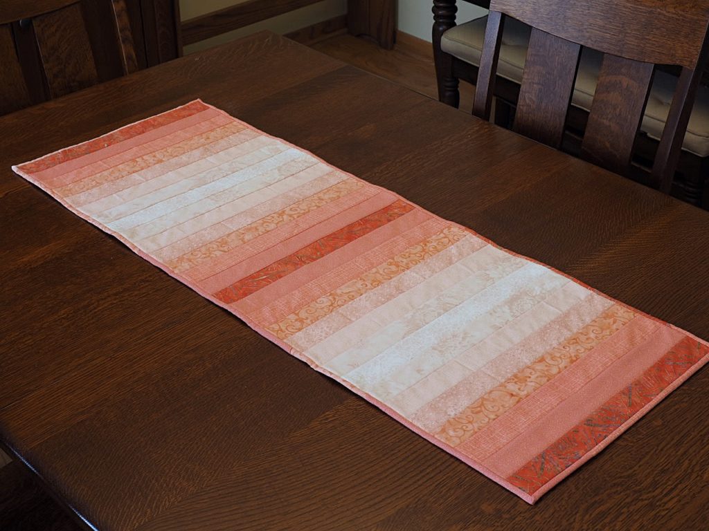 Tutorial demonstrating how to choose fabrics for an ombré (gradient) sewing project like a quilt or a table runner. createwithclaudia.com  #quilting #sewing #ombré