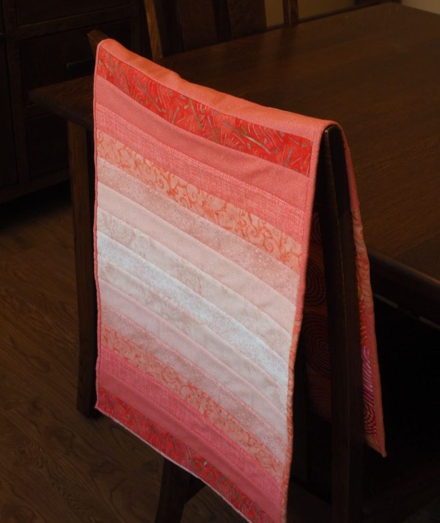 Tutorial demonstrating how to choose fabrics for an ombré (gradient) sewing project like a quilt or a table runner. createwithclaudia.com  #quilting #sewing #ombré