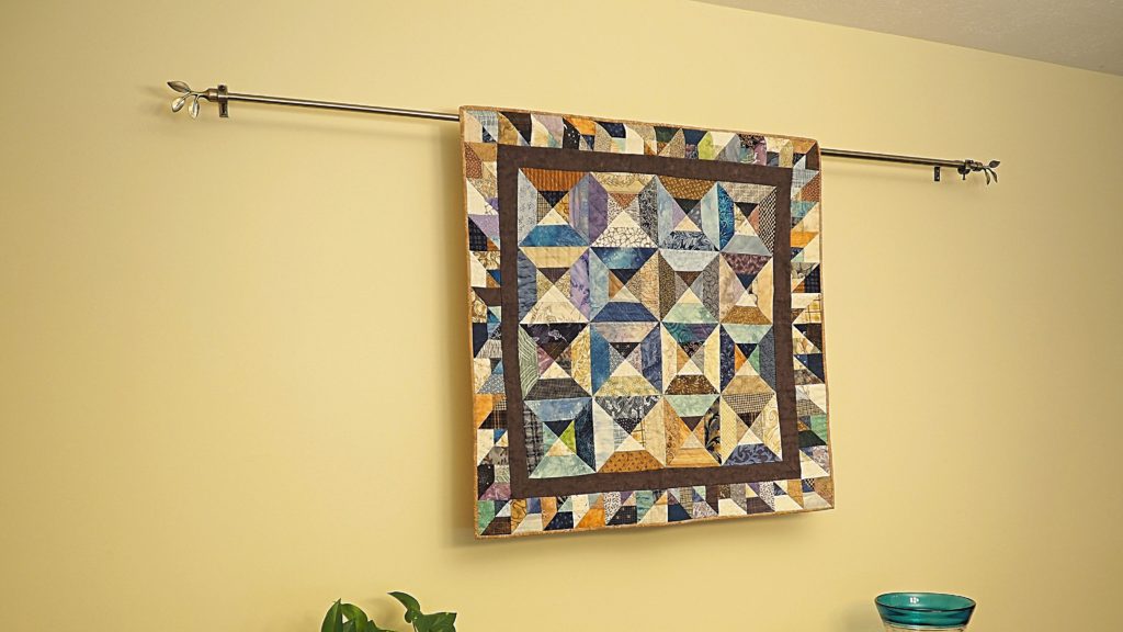 A curtain rod is an unexpected and practical method to show off quilts.